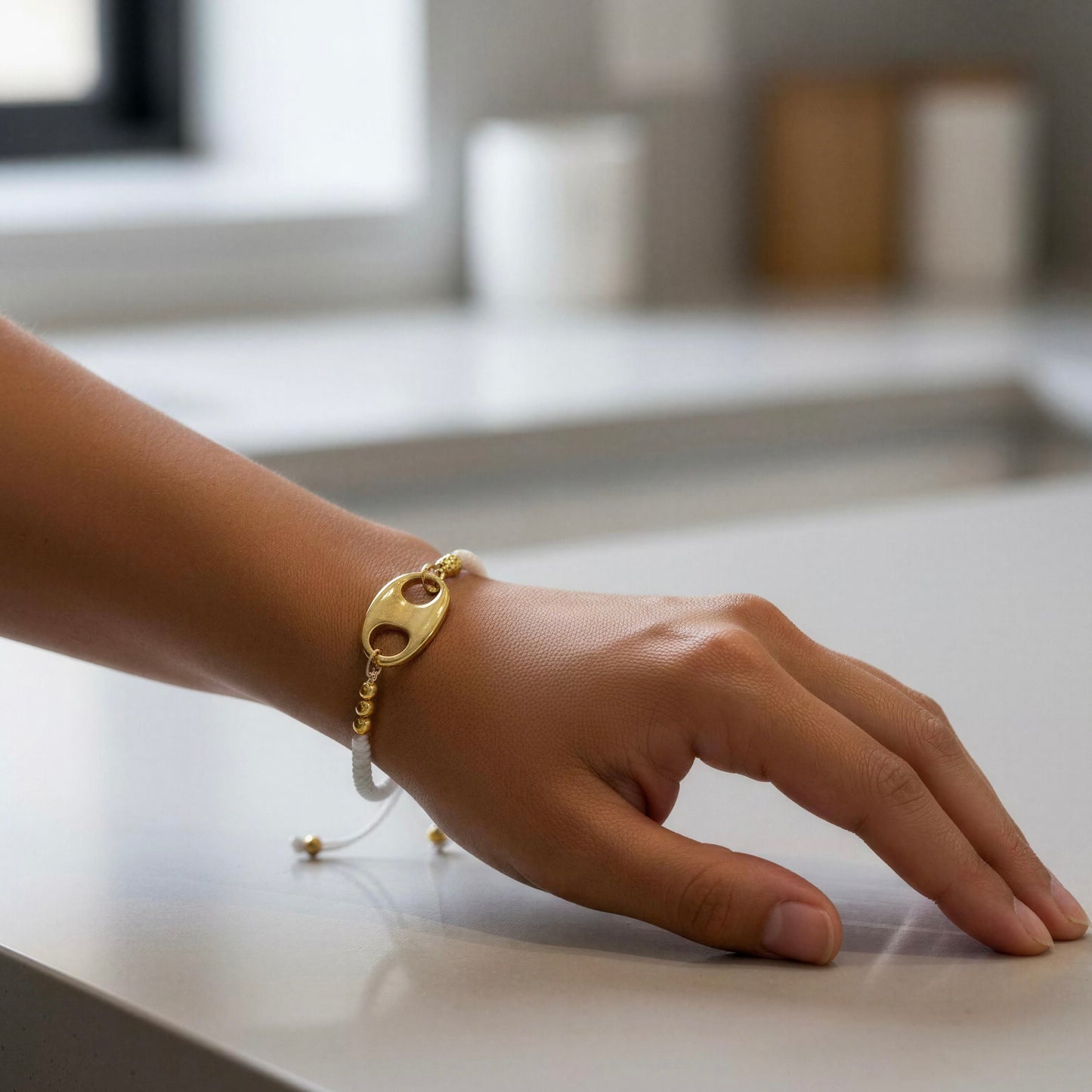 Hand wearing the Nexo Bracelet – White on a kitchen counter