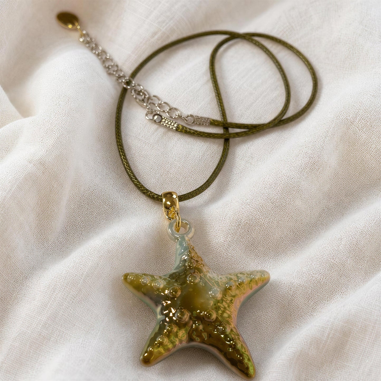 The Nerina Olive Necklace from Chica Chica Jewelry flatlay on linen fabric.