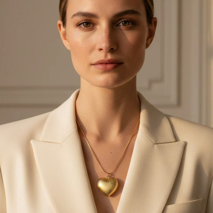 Textura gold heart necklace styled on model in white blazer, elegant everyday jewelry look