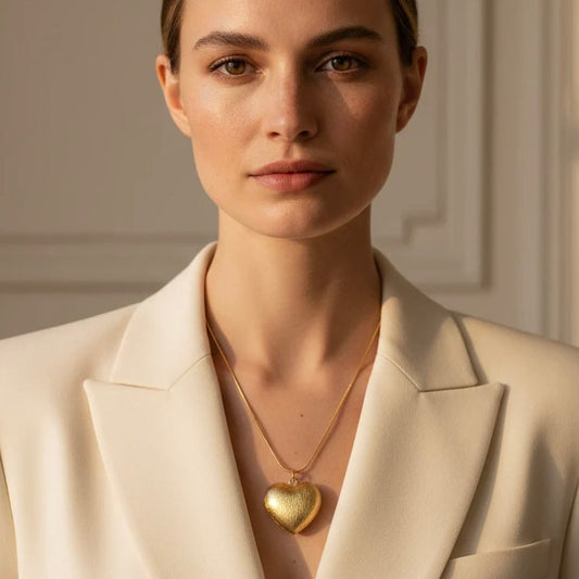 Textura gold heart necklace styled on model in white blazer, elegant everyday jewelry look