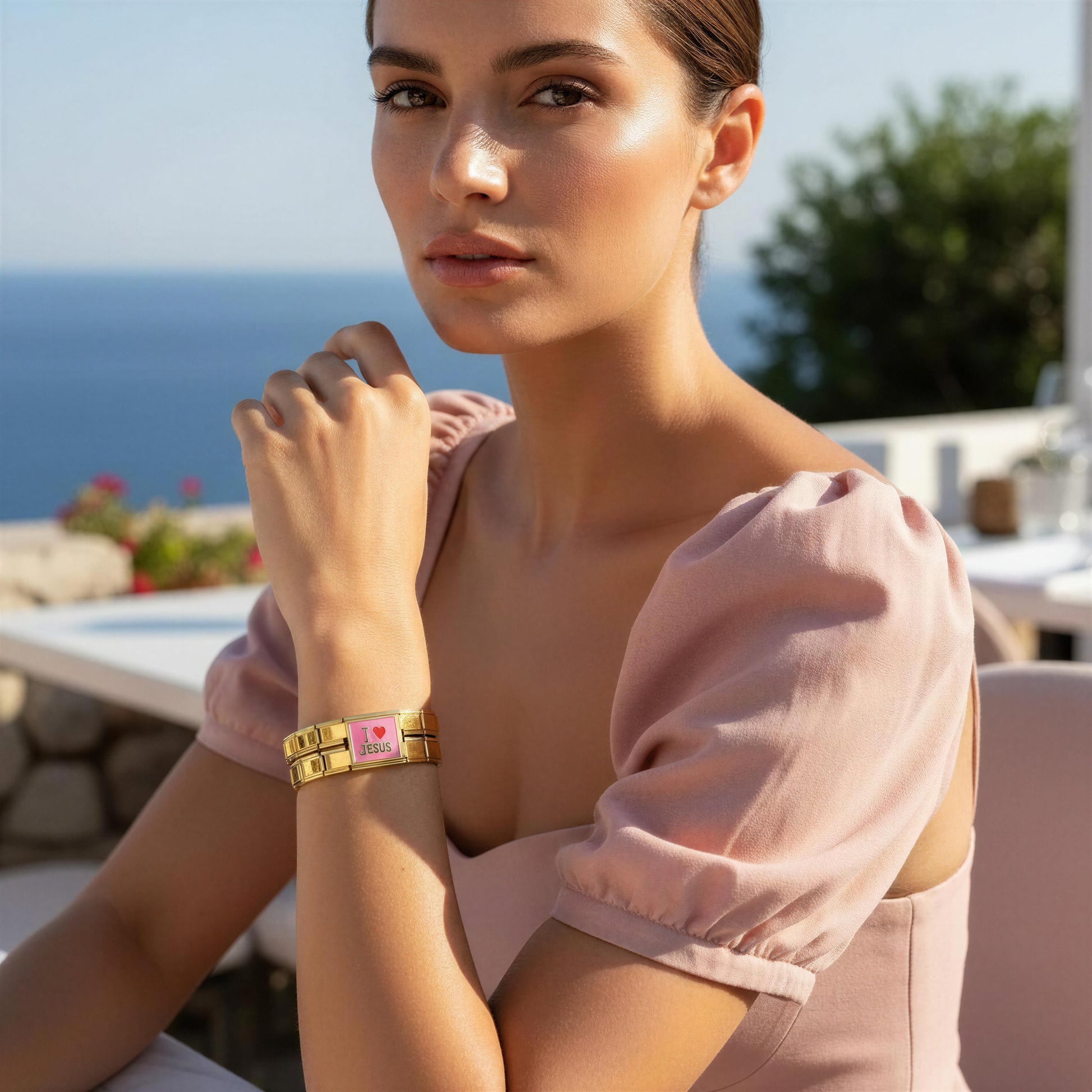 A woman wearing the Amada Italian Bracelet, posed outdoors with a sea and sky background.