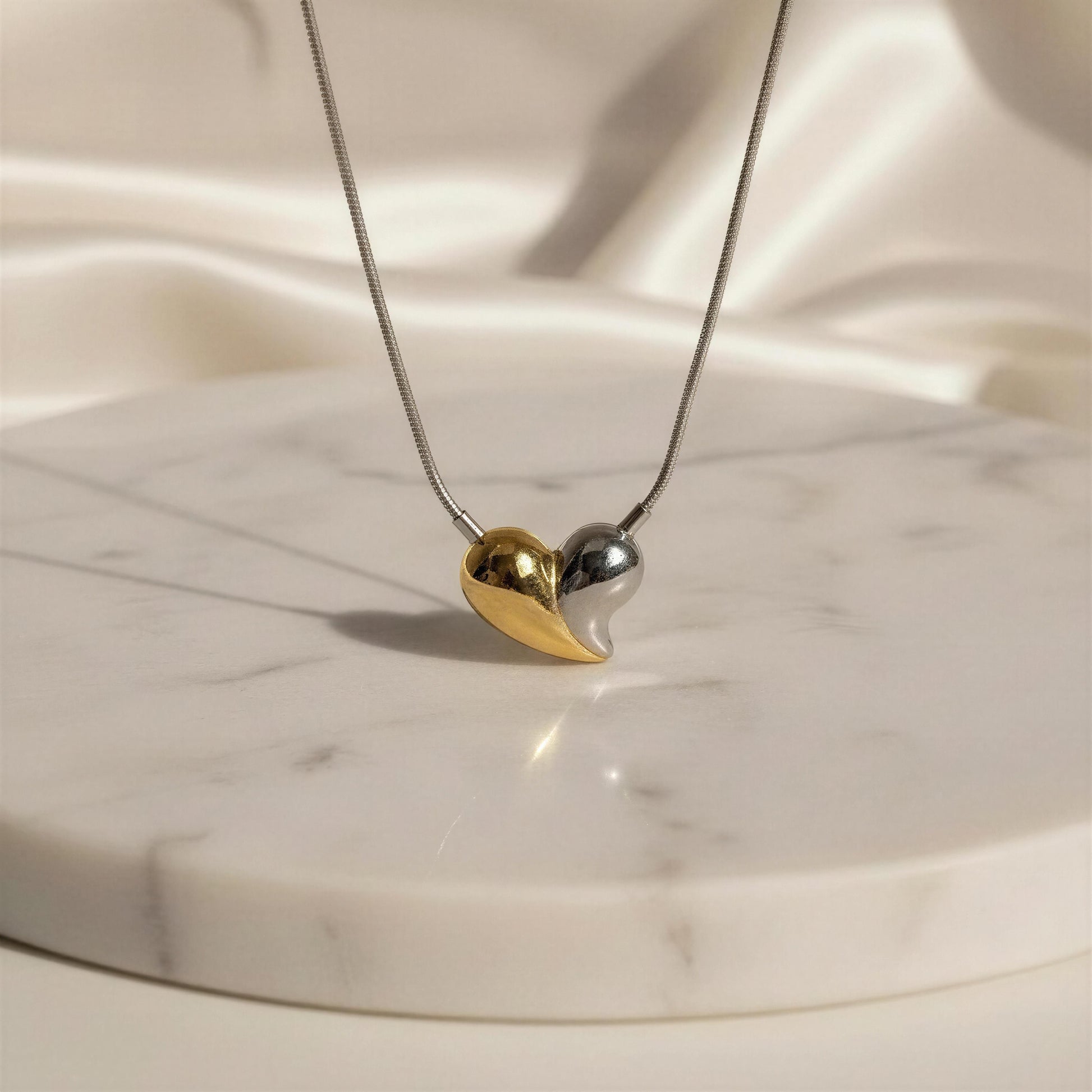 Necklace with a heart-shaped pendant on a marble surface