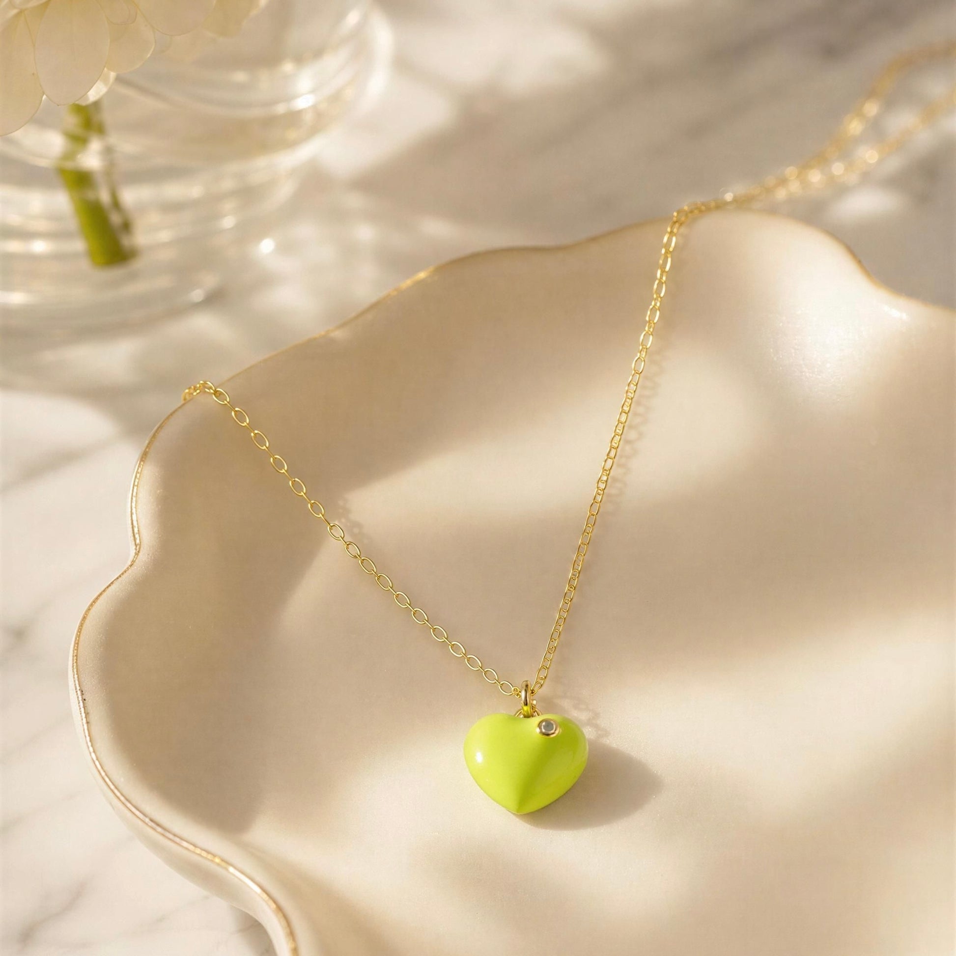 Necklace with a heart-shaped lemon color pendant on a light background