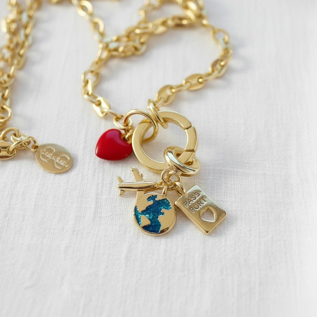 Gold necklace with various charms on a white background