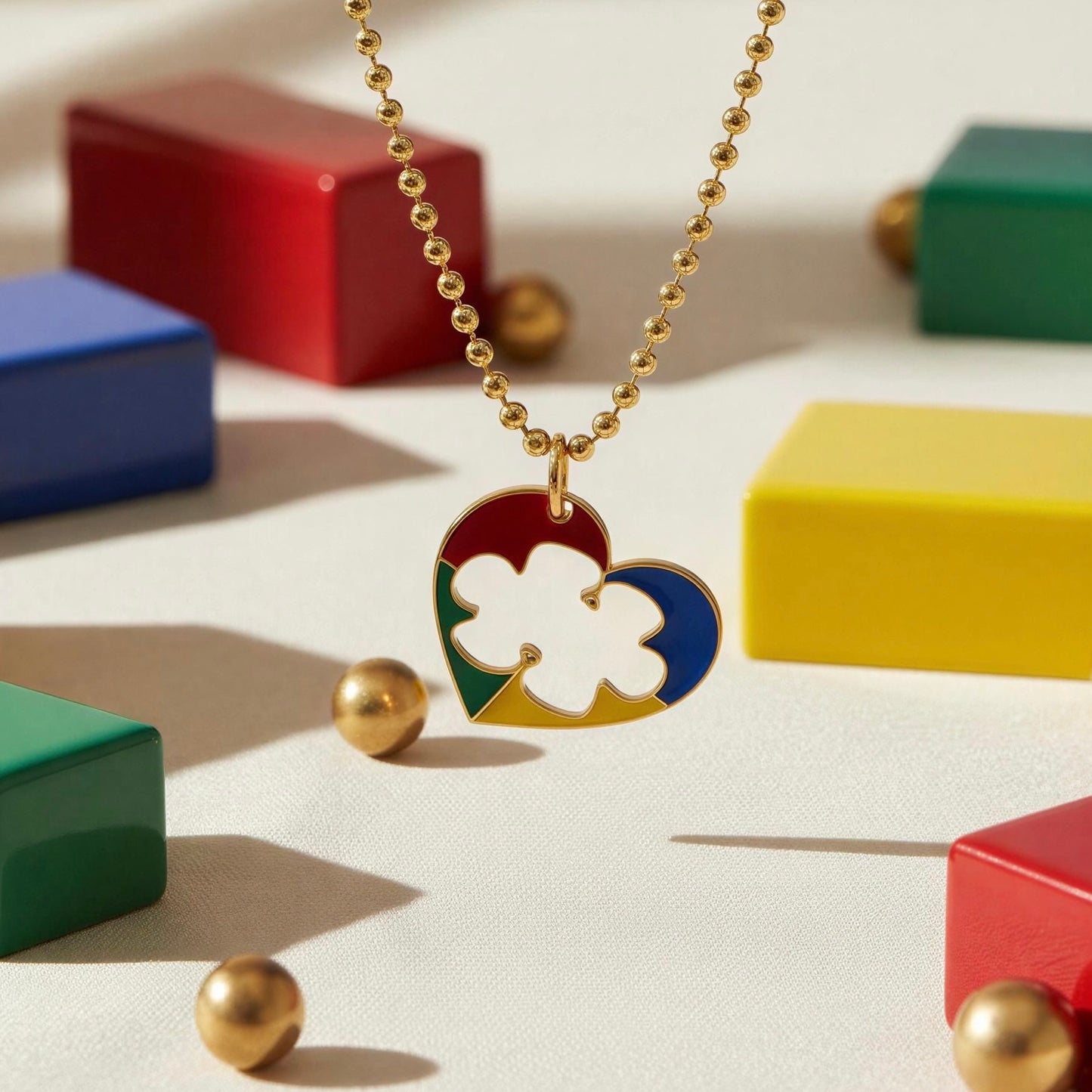 Autism Connection Necklace with a colorful heart pendant on a light surface with colorful blocks in the background