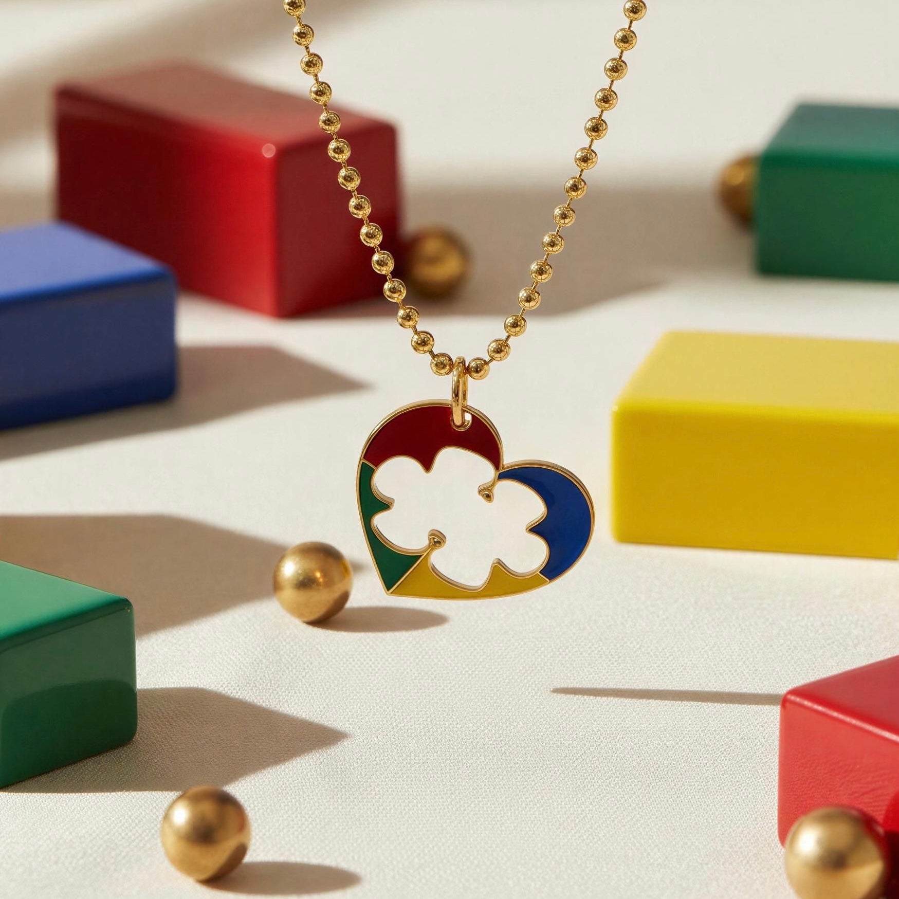 Autism Connection Necklace with a colorful heart pendant on a light surface with colorful blocks in the background