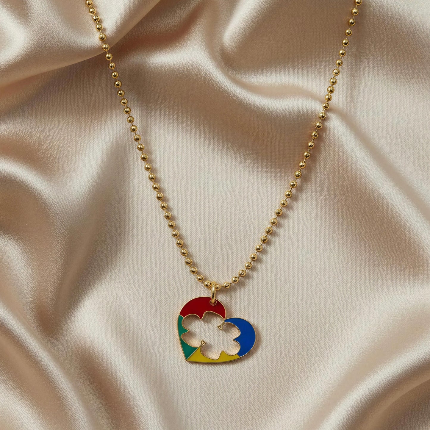 Necklace with a colorful heart-shaped pendant on a beige fabric background