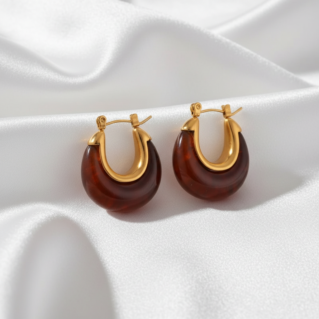 Gold Ava Hoop earrings in Amber on a white fabric background