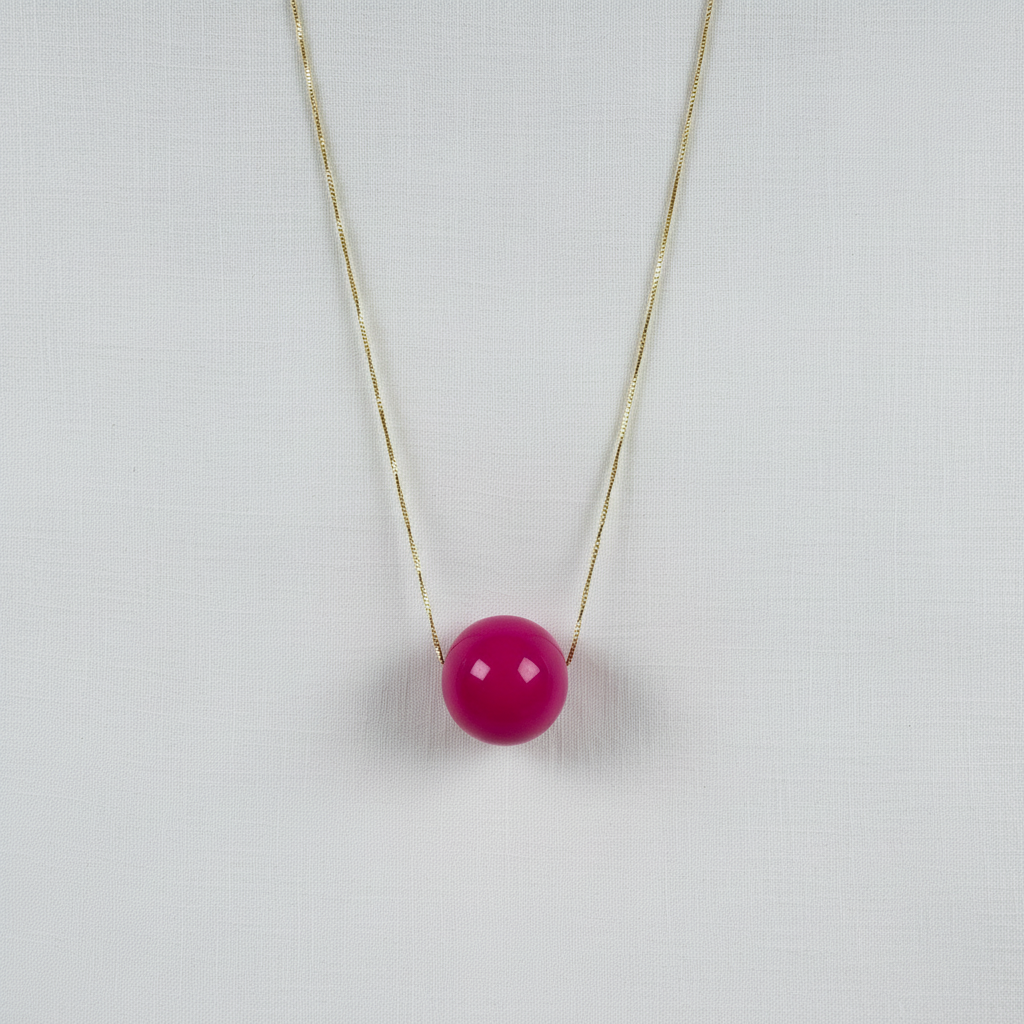 The Azalea Sphere Statement Necklace with a pink bead on a light gray background