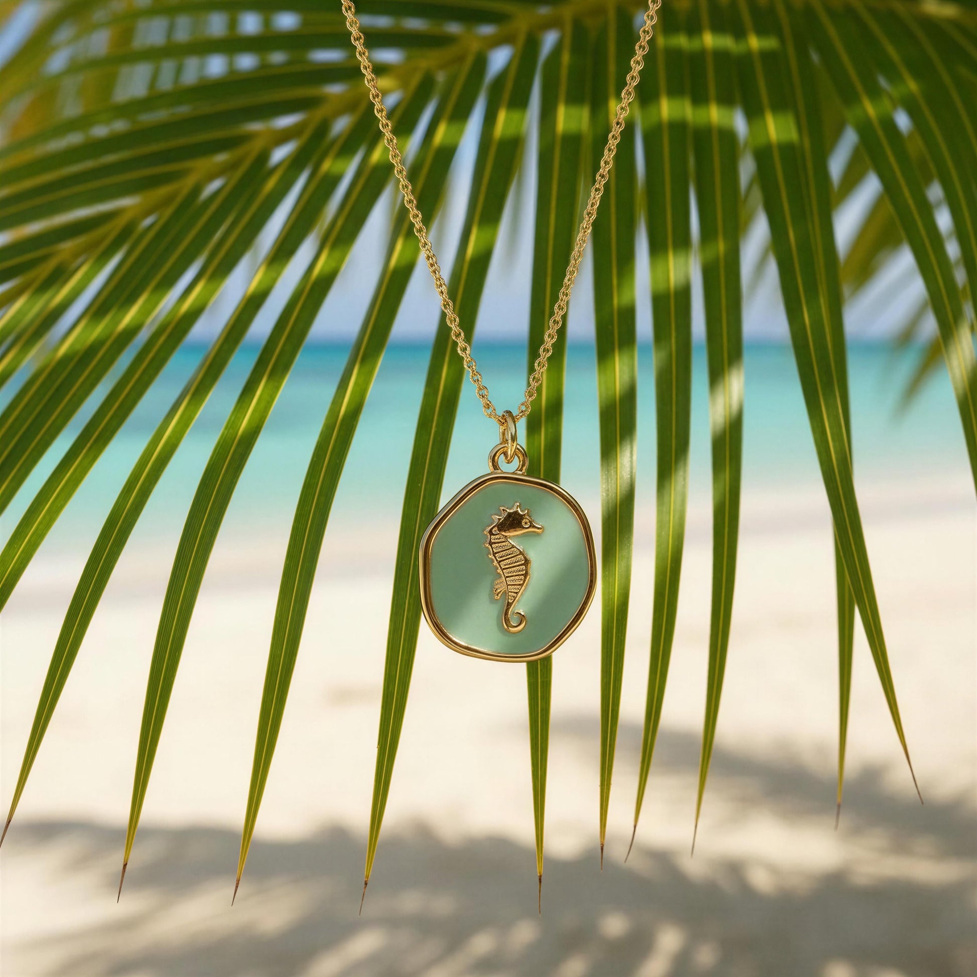 Necklace with a seahorse pendant against a tropical background with palm leaves and beach.