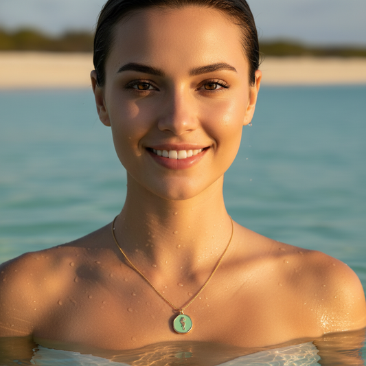 Woman with the Azure Seahorse Necklace from Chica Chica Jewelry  standing in water with a blurred beach background