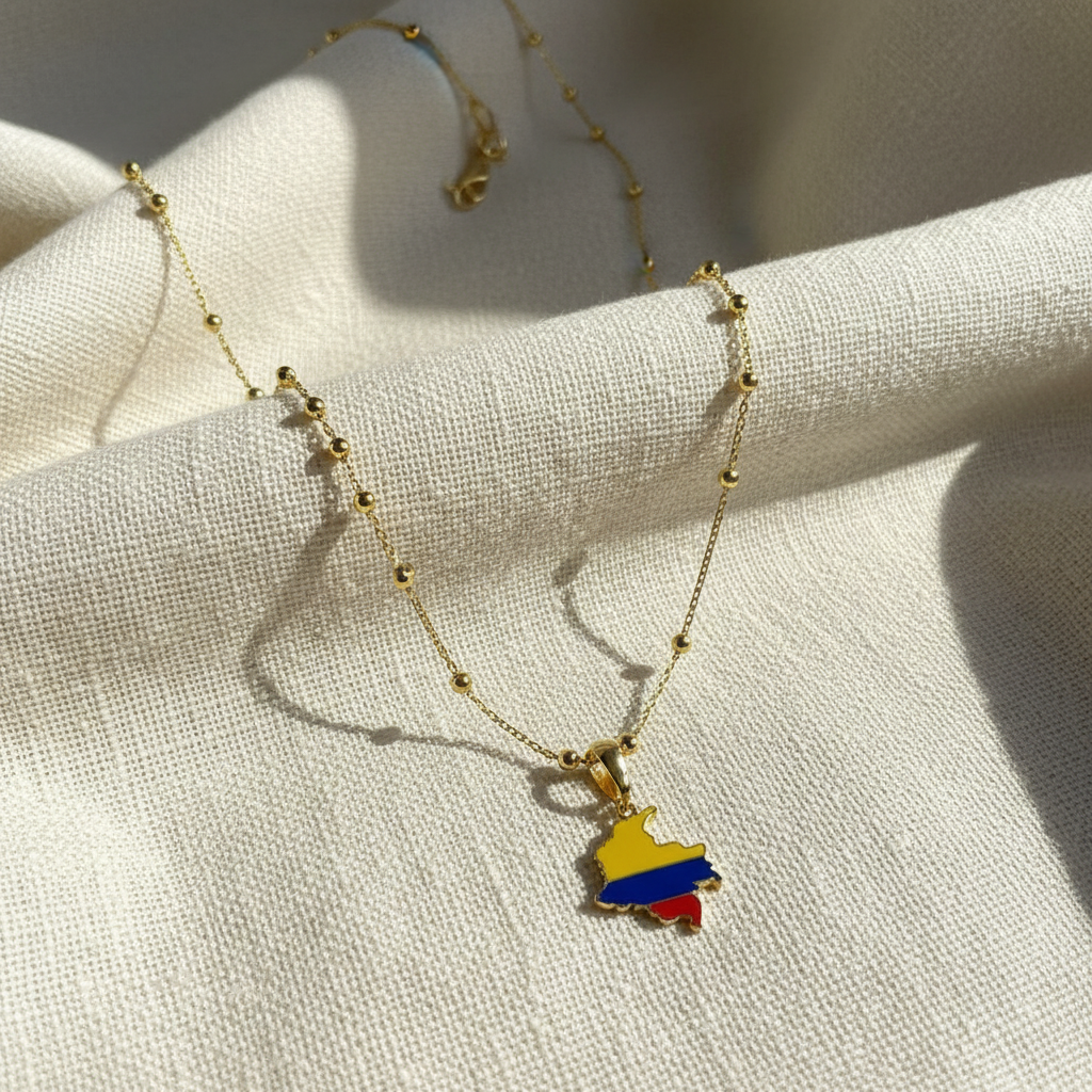 The Bacata Necklace with the Colombian map  pendant on a light fabric background.