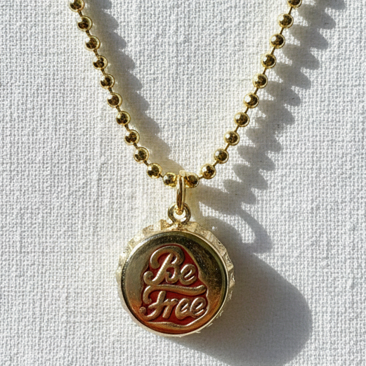 Gold Chica_Chica_Jewelry necklace with a round pendant on a white background