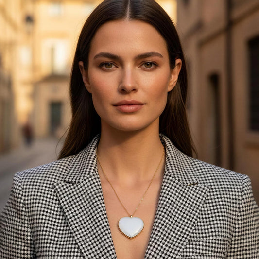 Woman wearing a checkered blazer with a blurred street background wearing the  Bianca Heart Necklace
