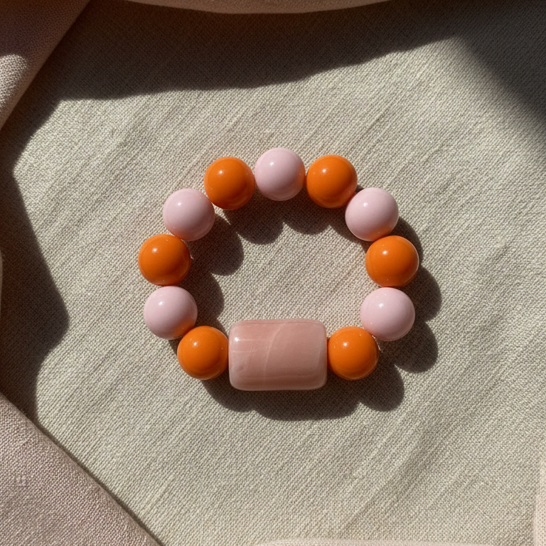 Blush & Citrus Color Pop Bracelet with orange and pink beads on a textured surface