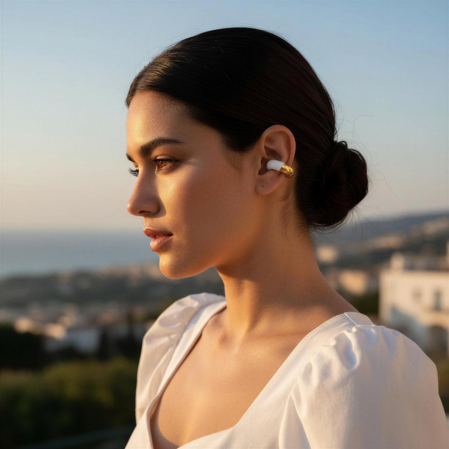 Woman wearing the Gatsby Arc Ear Cuff – Milky White with a scenic background