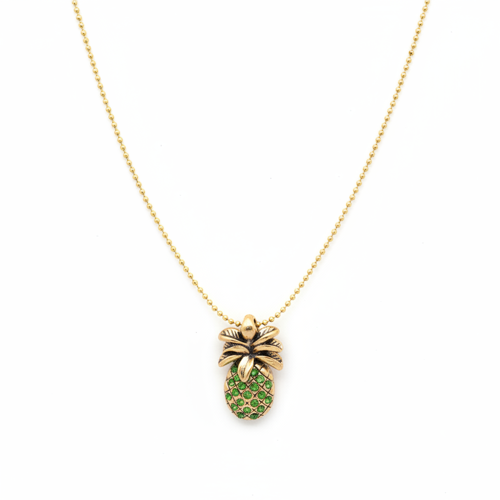 Gold necklace with a pineapple pendant featuring green stones on a white background