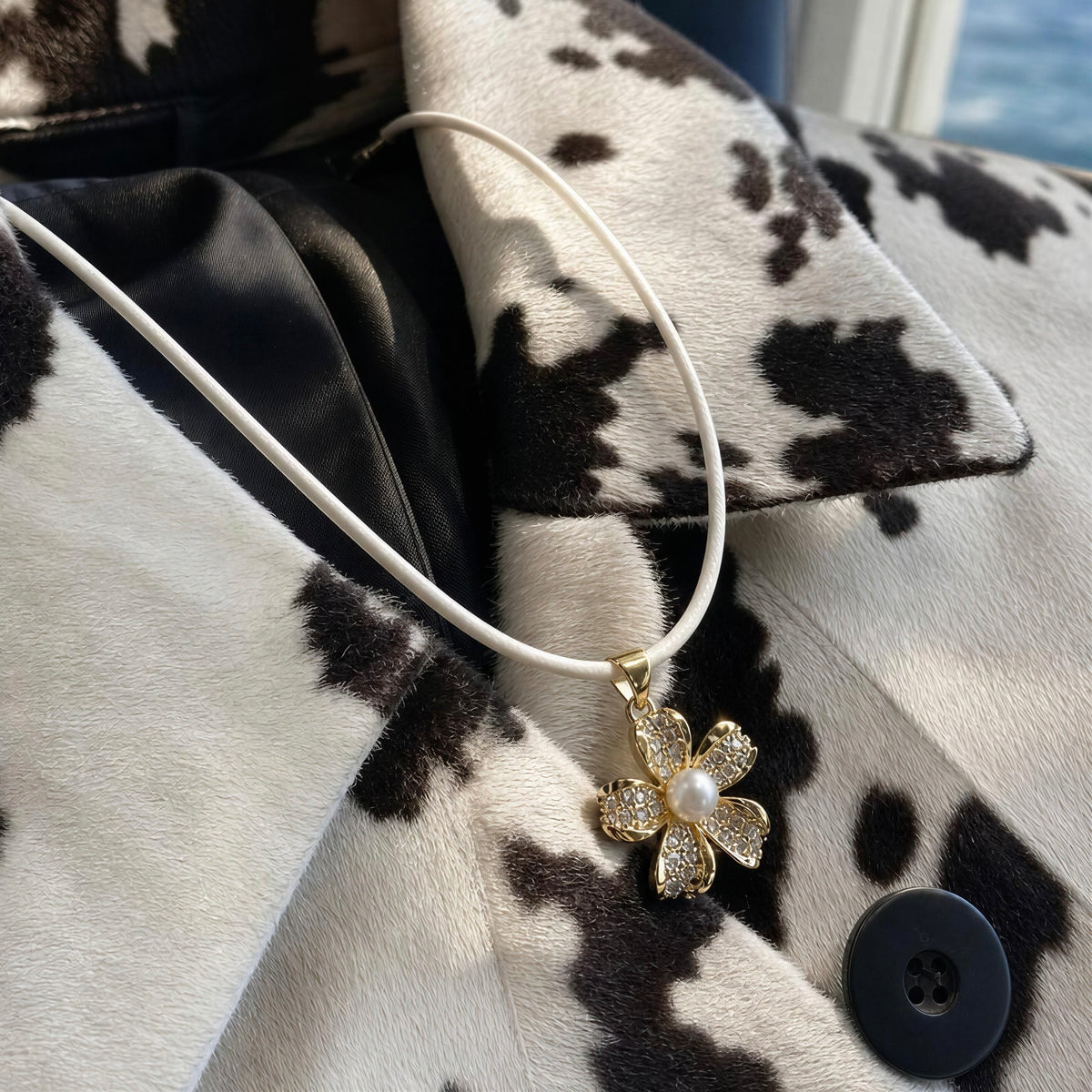 The Camellia Necklace from  Chica Chica Jewelry against a cow jacket.
