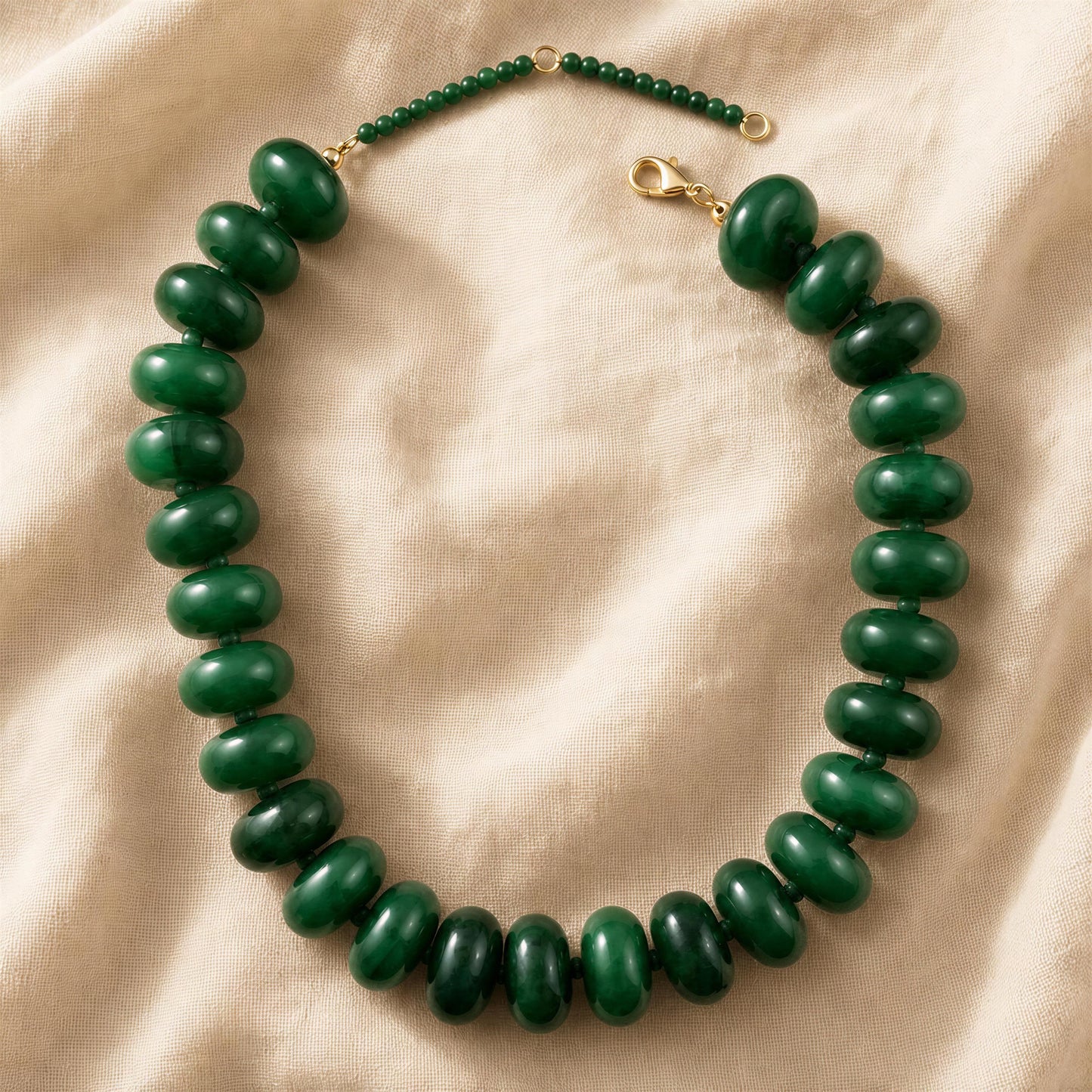 Green beaded resin necklace on a beige fabric background