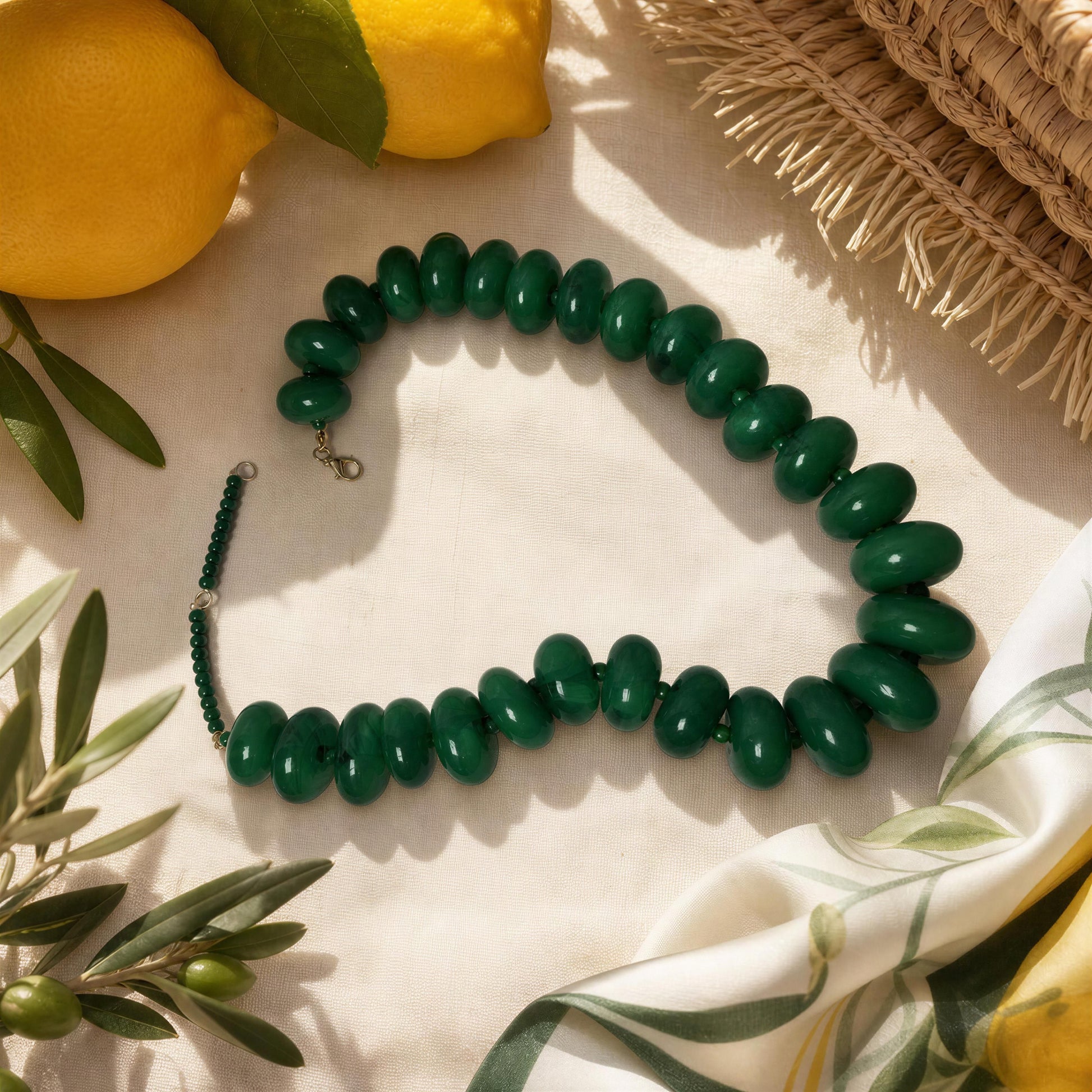 The Capri Verde Statement Choker on a light background with lemons and leaves