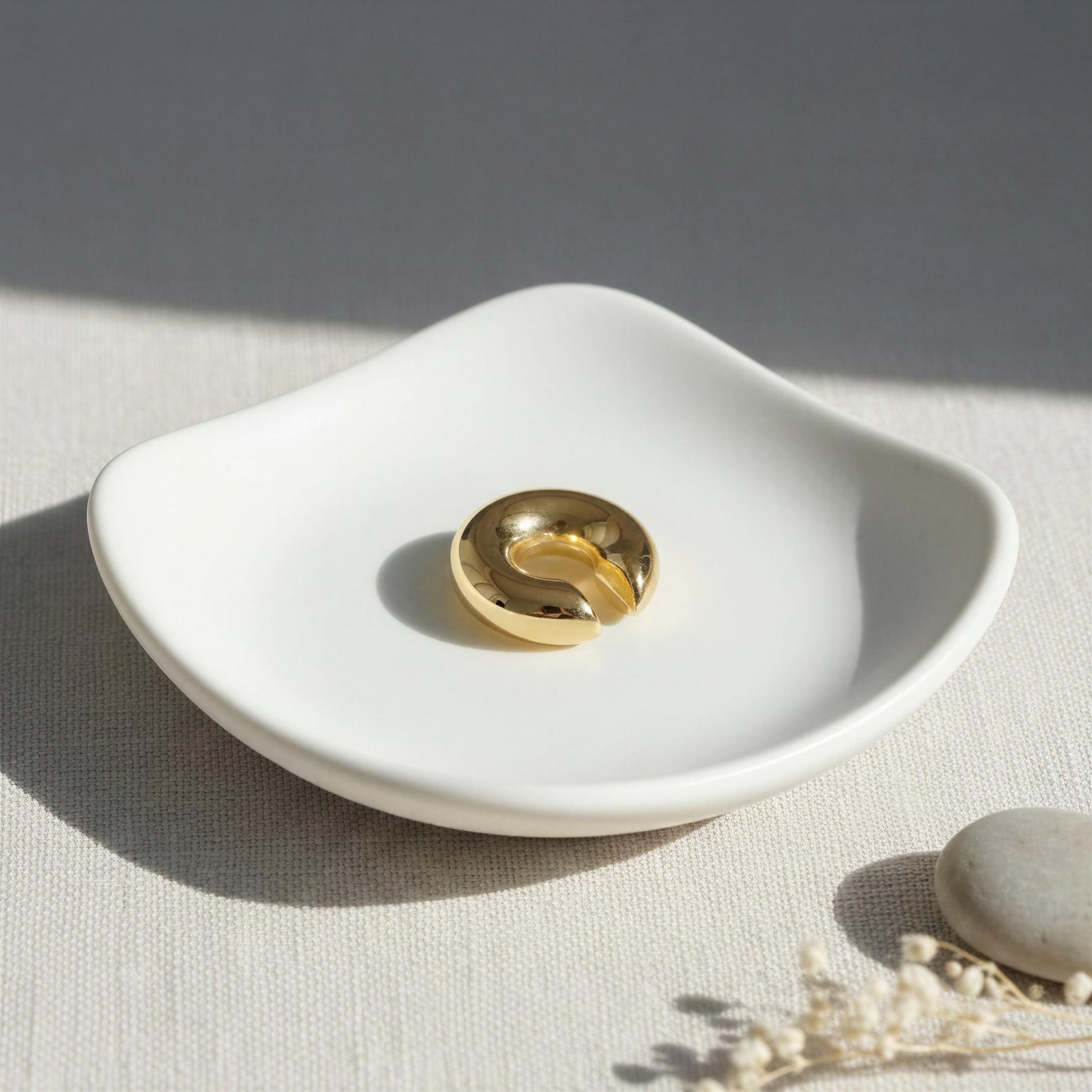 Lunar Orbit Ear Cuff on a white ceramic dish with a neutral background