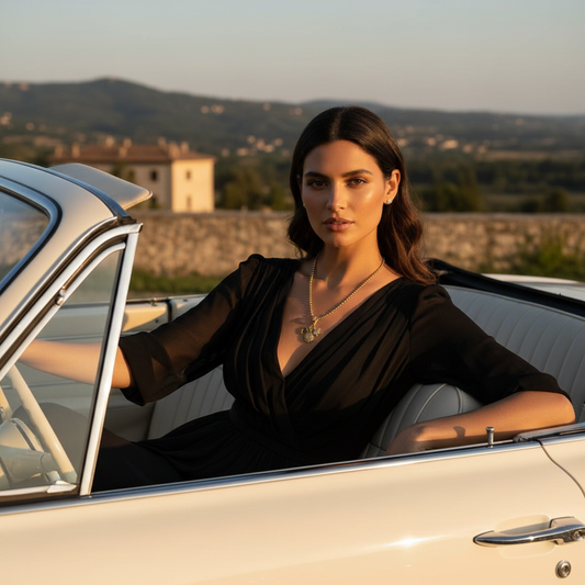 Woman sitting in a vintage car with a scenic background wearing the Celestial Trinity Charm Necklace 
