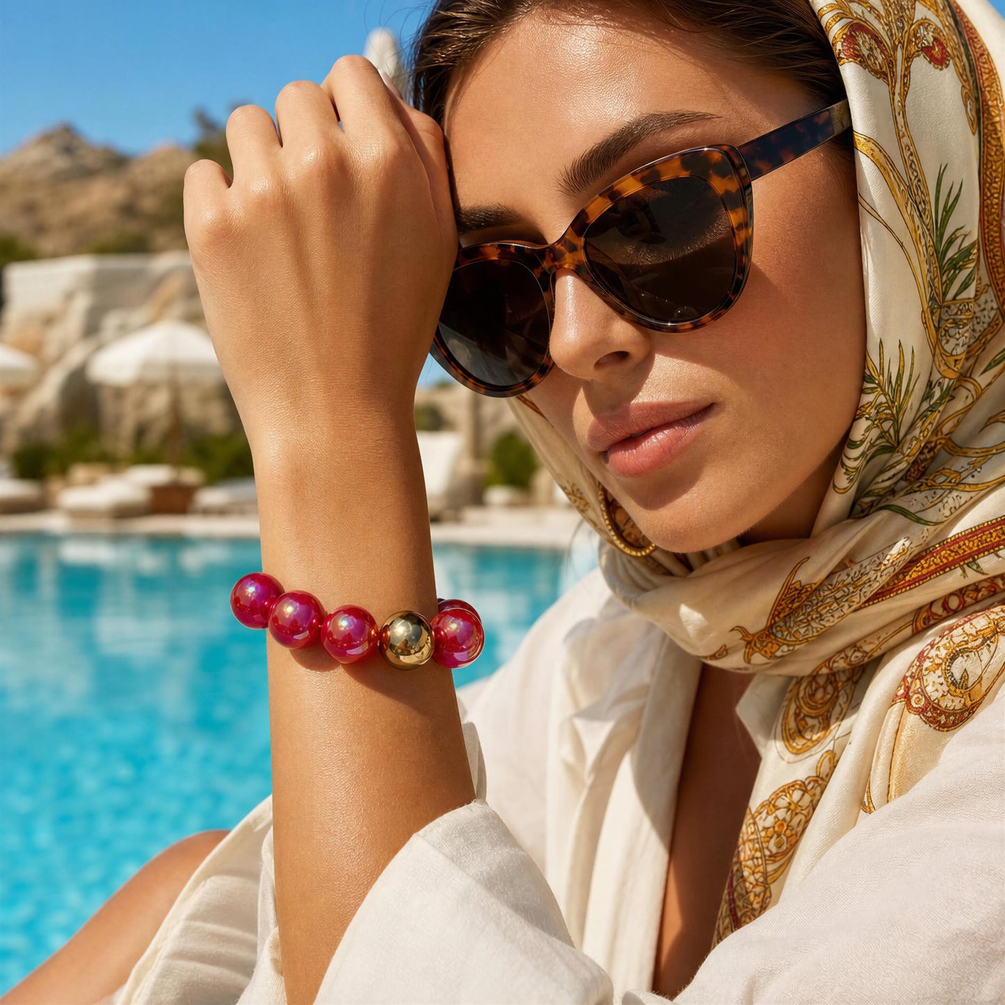 Model wearing the Cherry Glow Bracelet by resort pool 