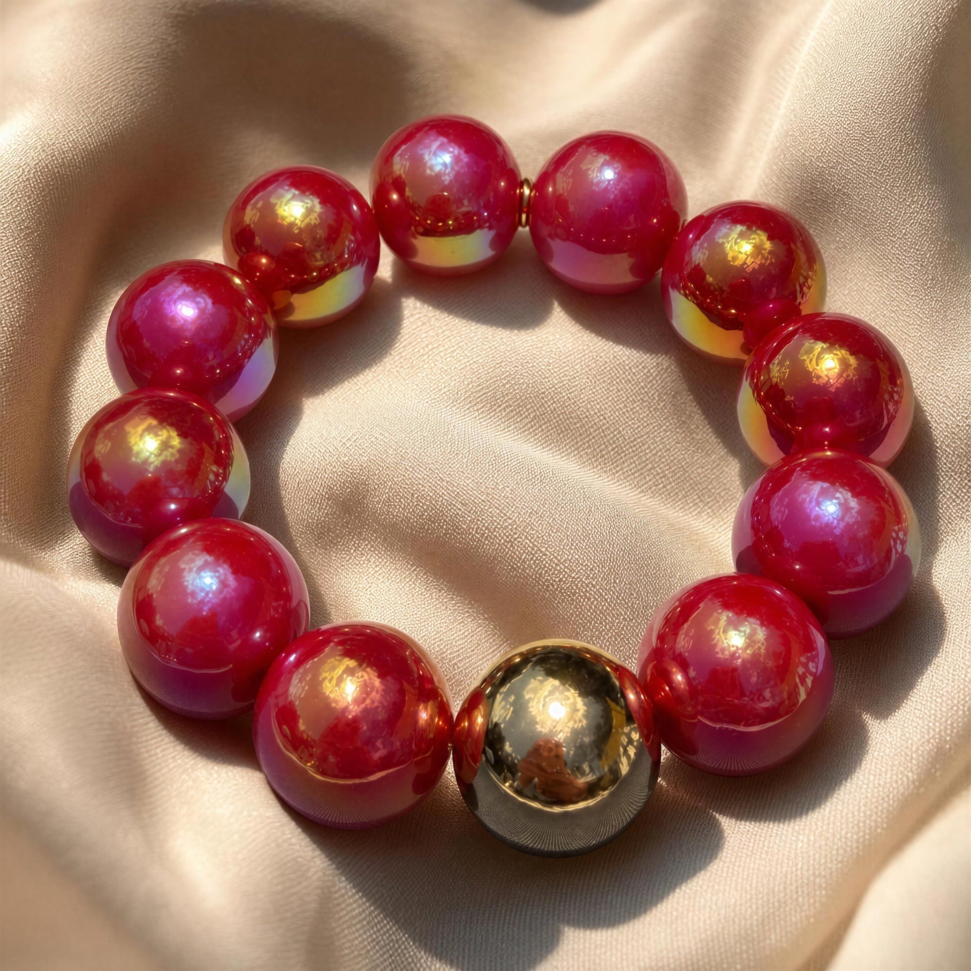 The Cherry Glow Bracelet on a beige fabric background