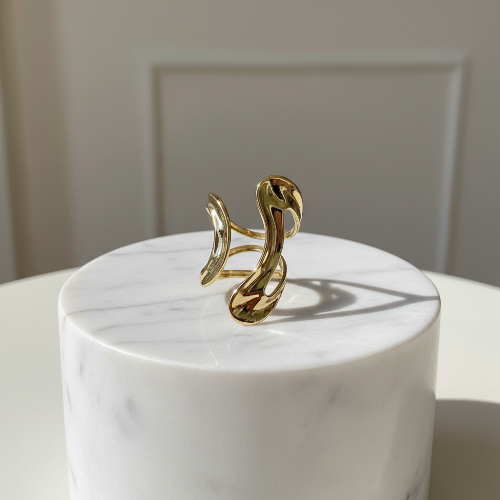 The Aurea Ring from Chica Chica Jewelry on a marble pedestal with a neutral background