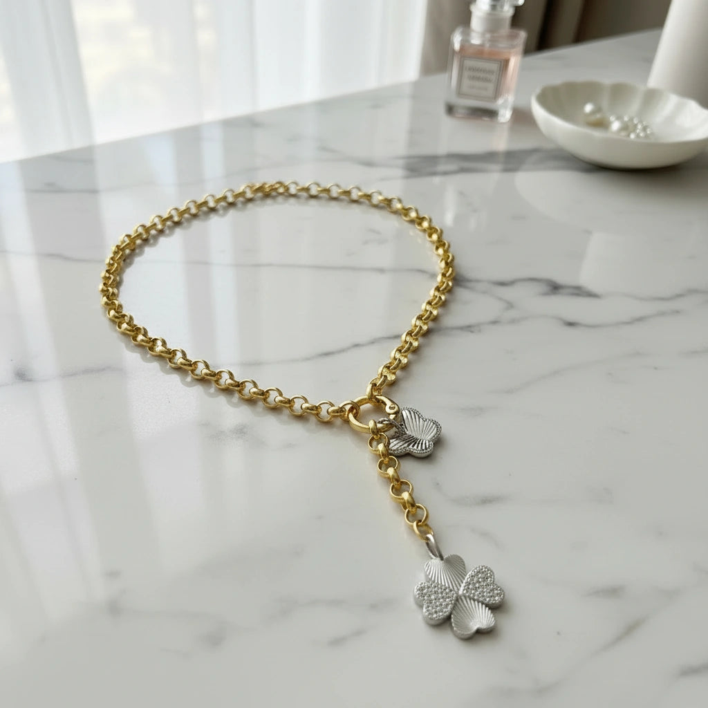 The Lucky Flutter Slip-On Necklace  with silver charms on a marble surface