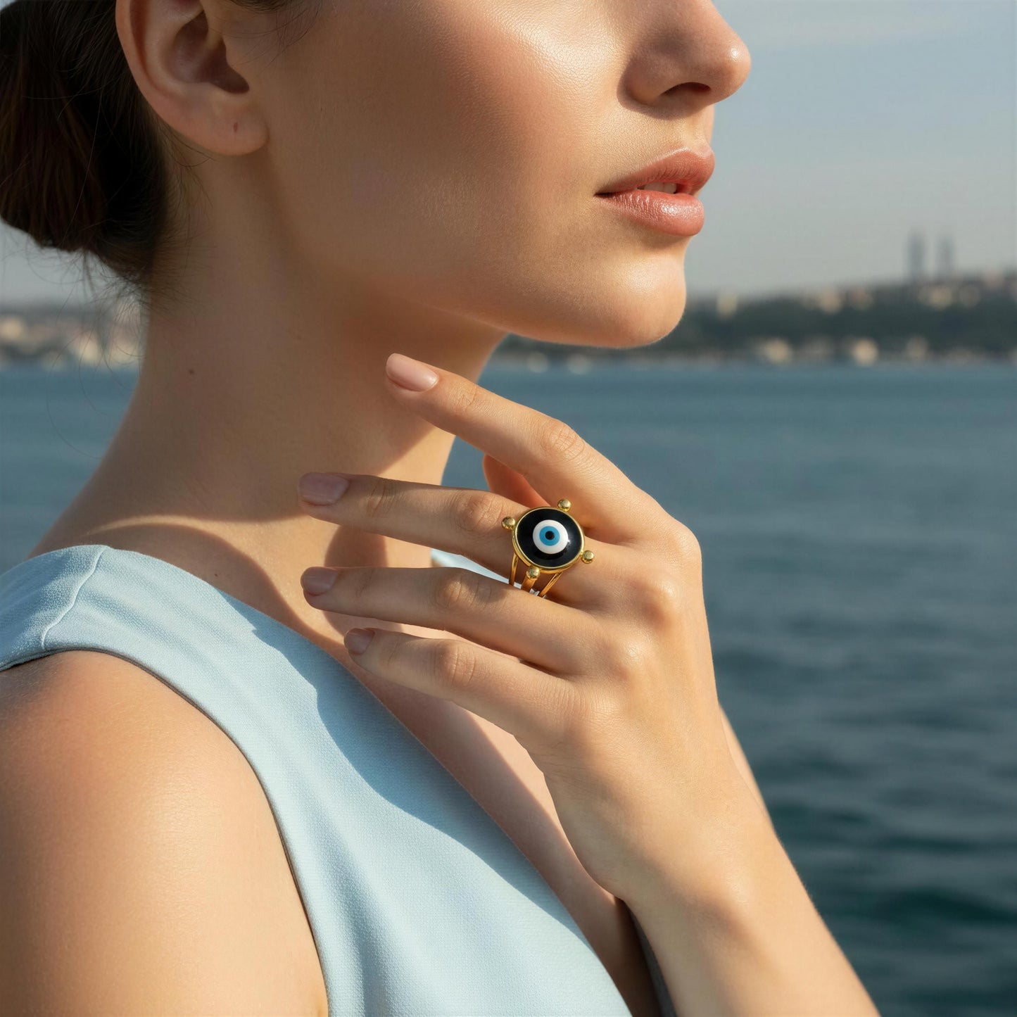 Woman wearing the  Nazar Aura Ring with an eye design by the water.