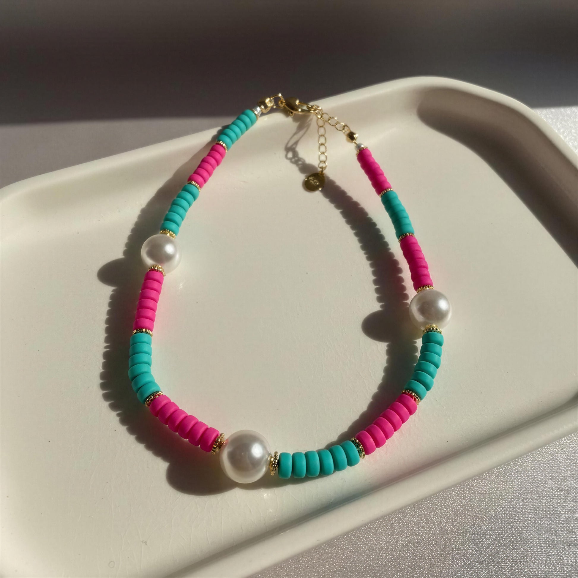 Colorful beaded bracelet with pearls on a white surface