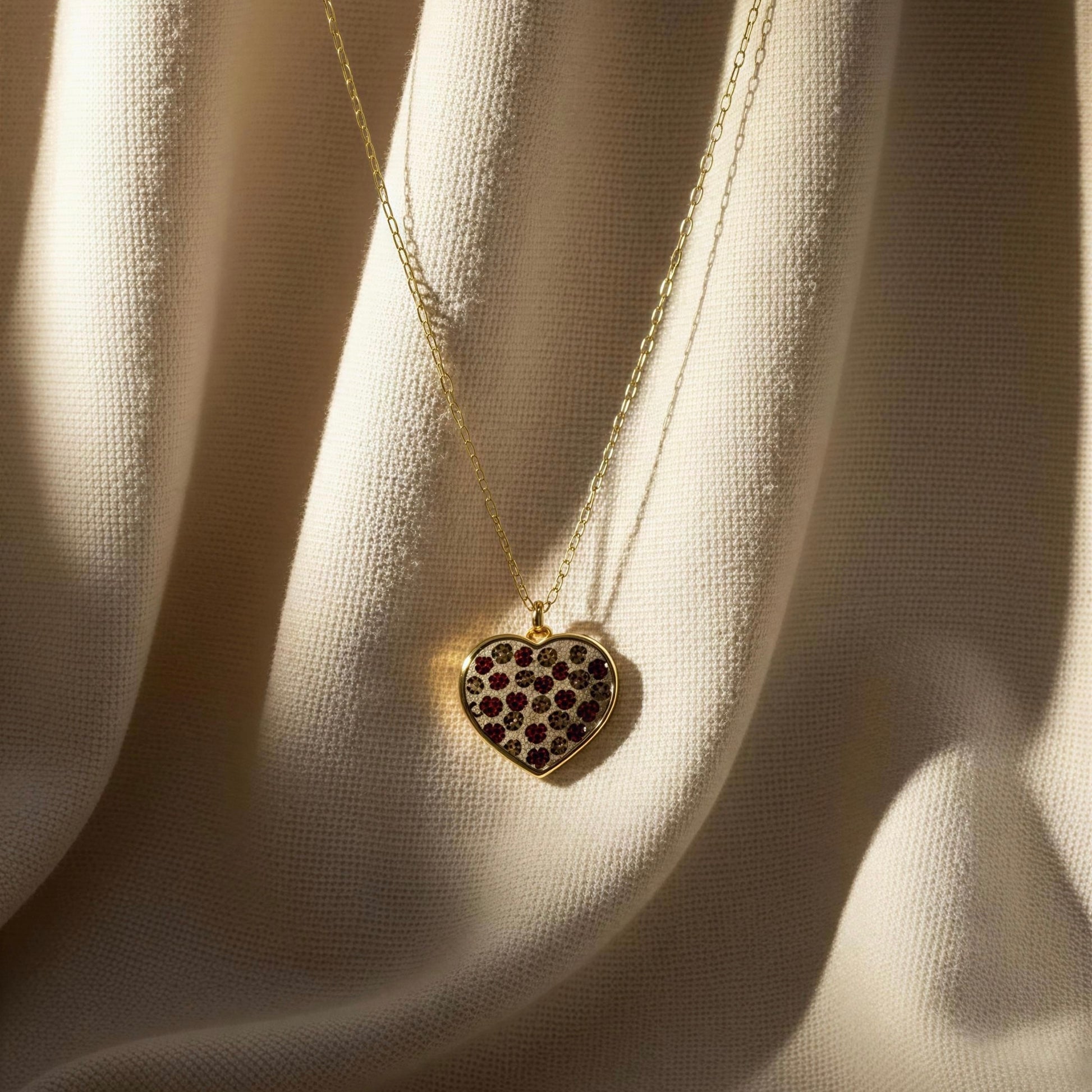 The Wildheart Necklace-  a heart-shaped pendant on a beige fabric background
