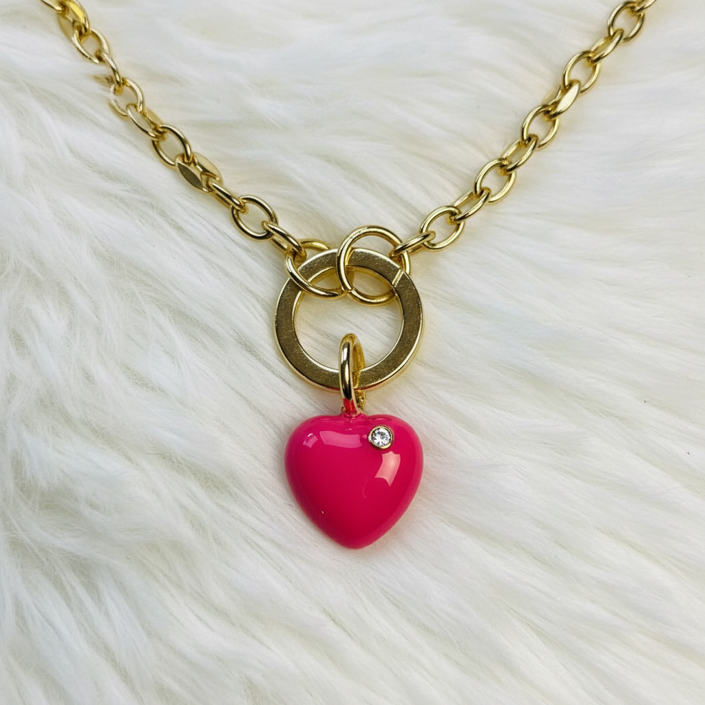Gold necklace with a pink heart pendant on a white fur background