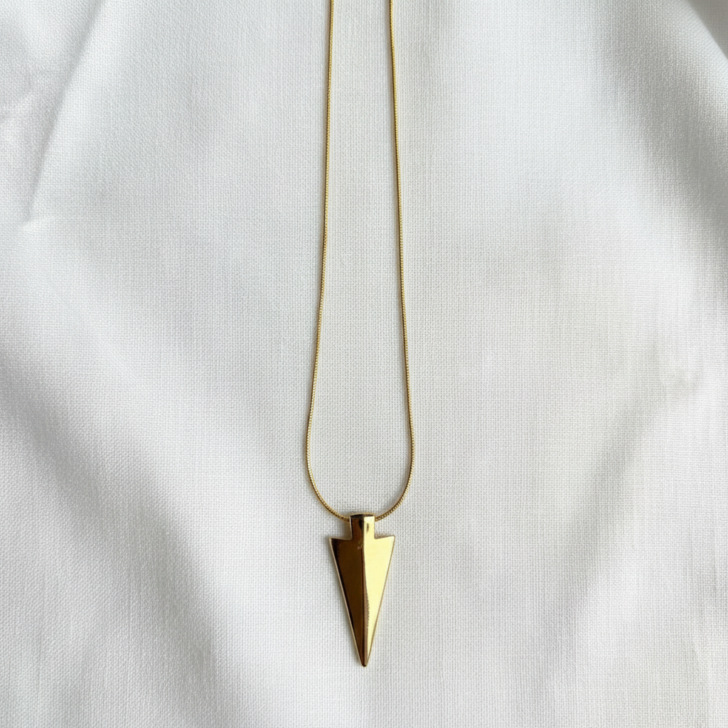 Gold necklace with a triangular pendant on a white background