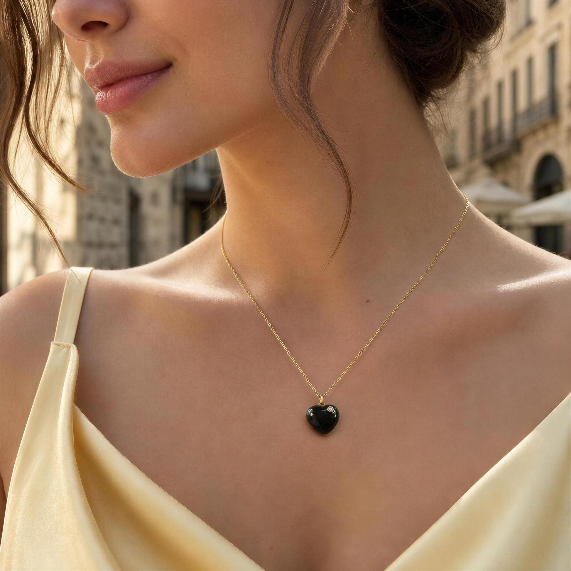 Woman wearing the Amore Noir Heart Necklace with a black heart pendant in an urban setting