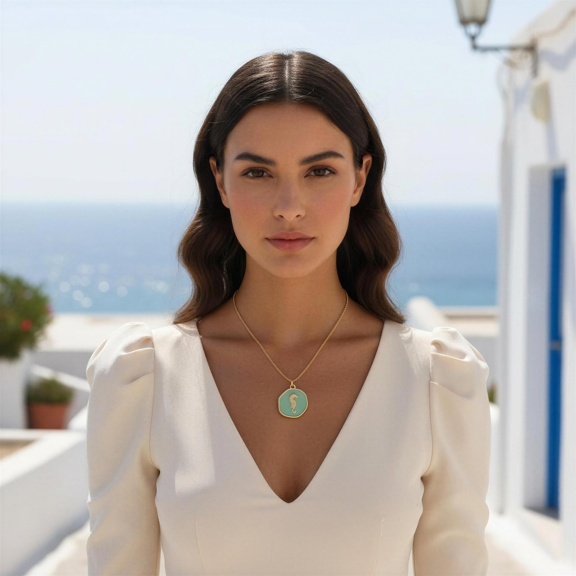 Woman wearing the Azure Seahorse Necklace with a scenic background