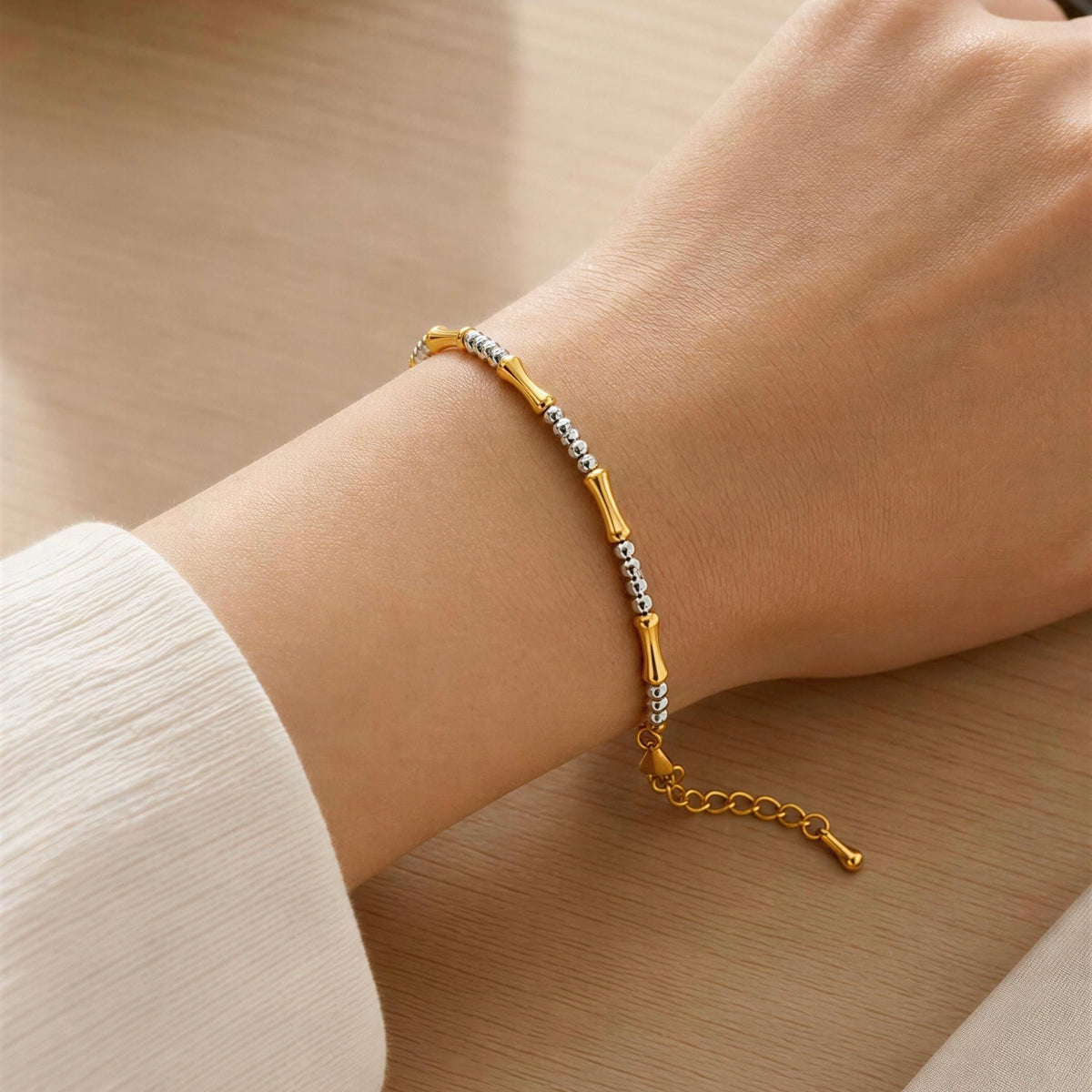 The Chica Chica Jewelry -  Malta Bracelet  worn on a person's wrist against a warm wood background.