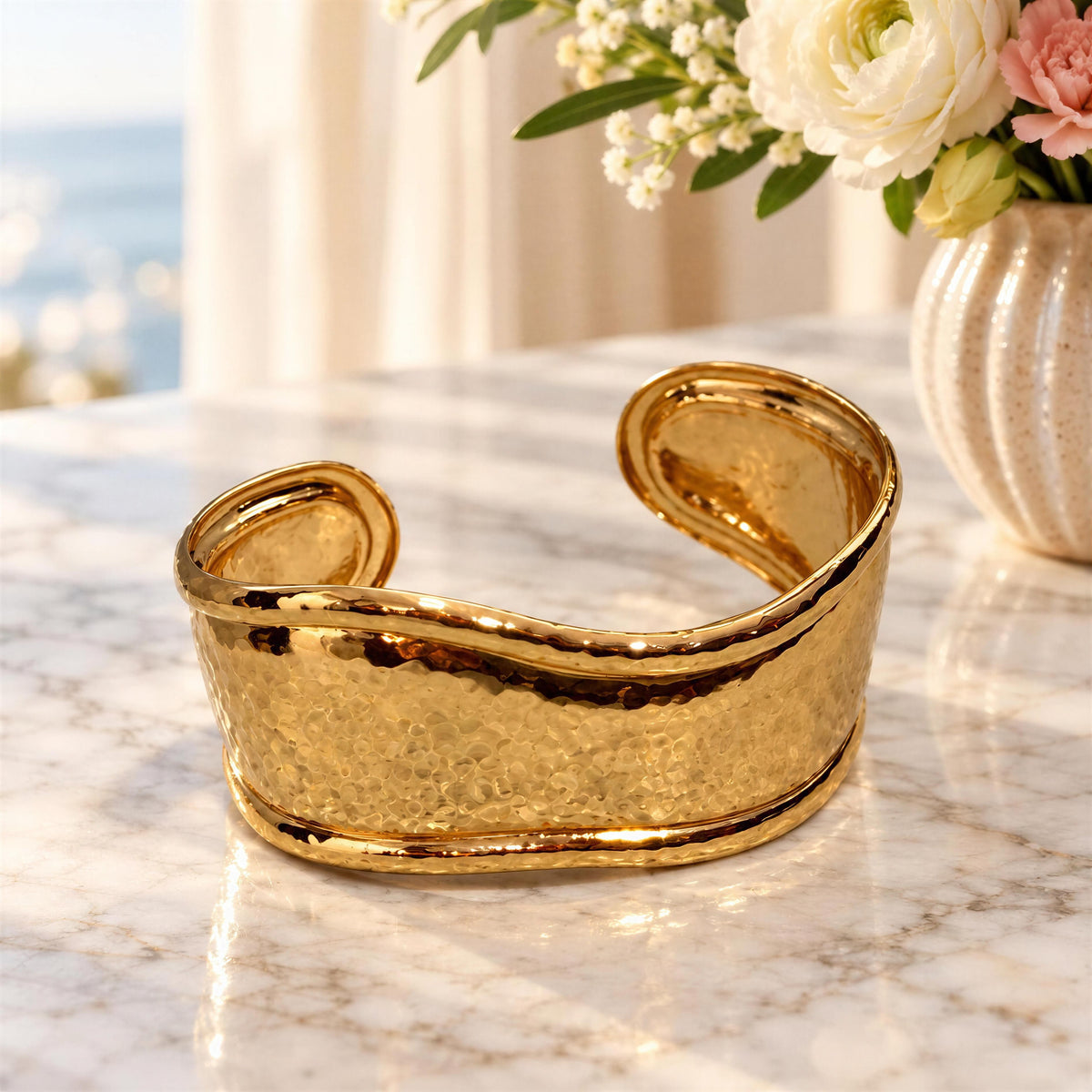 Forma Gold open cuff bracelet with subtle hammered texture on marble