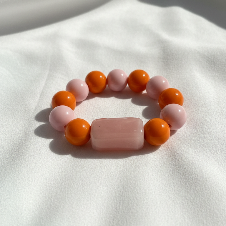 Beaded Chica Chica Jewelry Blush & Citrus Color Pop Bracelet  with pink and orange beads on a white fabric background