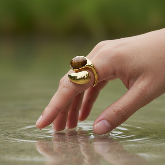 Hand with the Molten Terra Ring touching water, with a blurred natural background