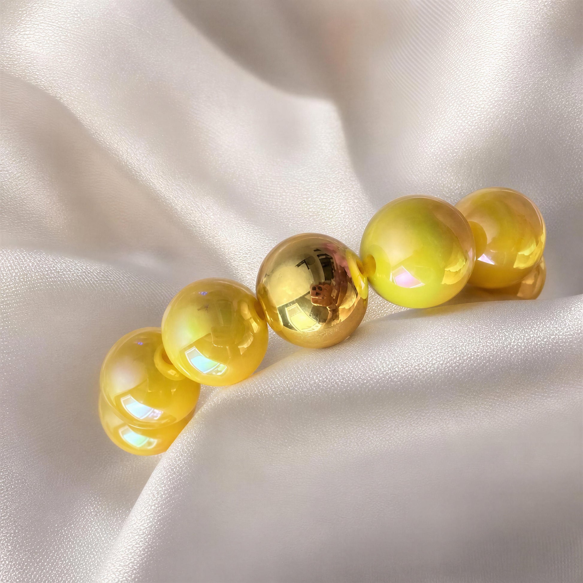 Gold and yellow beaded bracelet on a satin surface