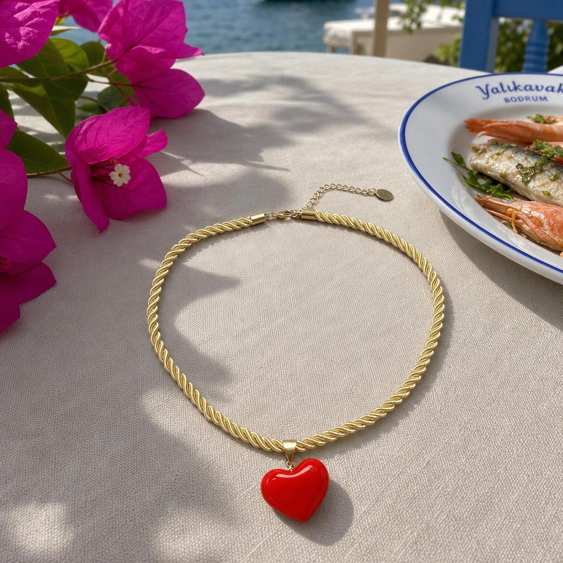 The Corallo Necklace by Chica Chica Jewelry placed flat lay at a seaside restaurant overlooking the Bodrum coastline, Turkey.