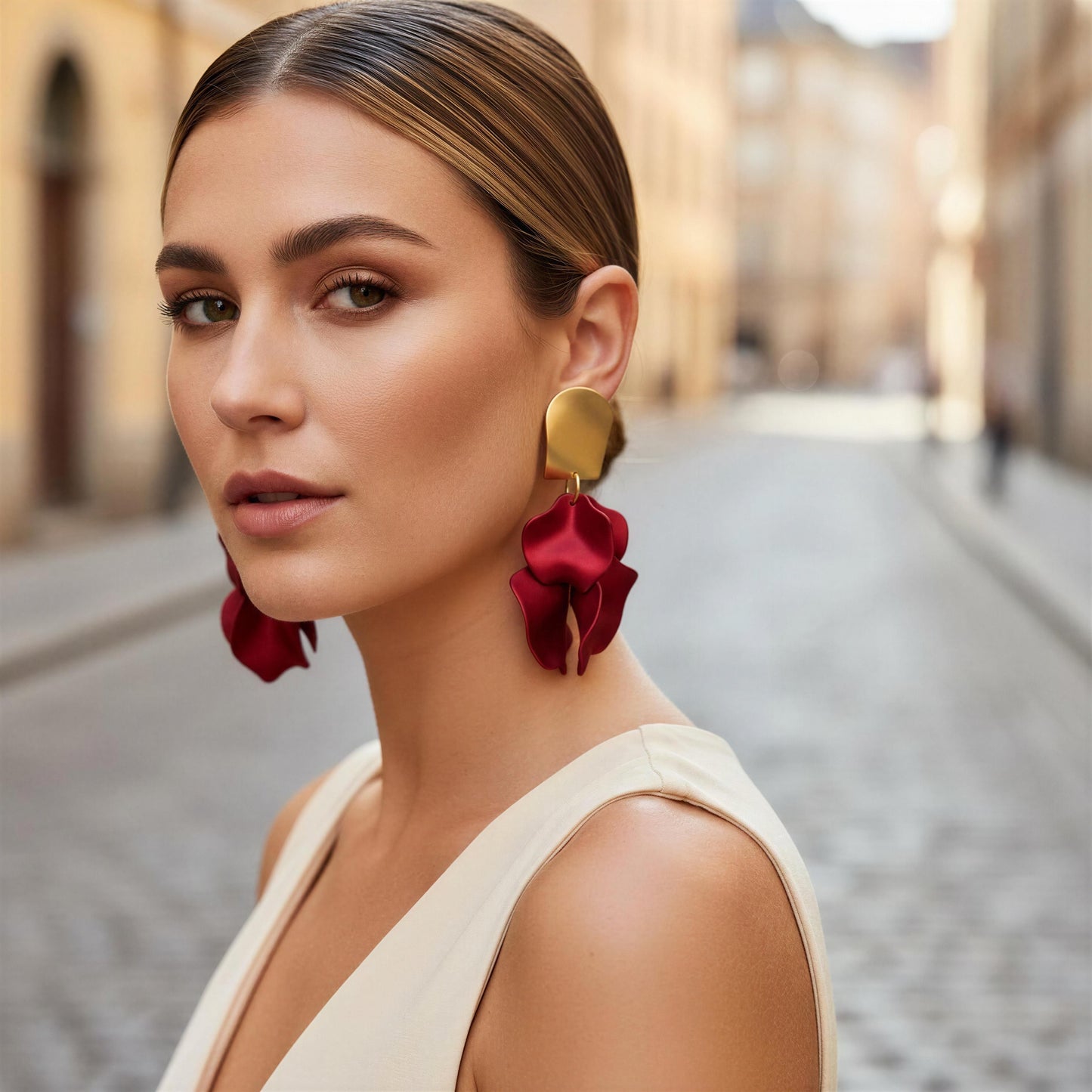 Woman wearing red floral earrings with a blurred street background