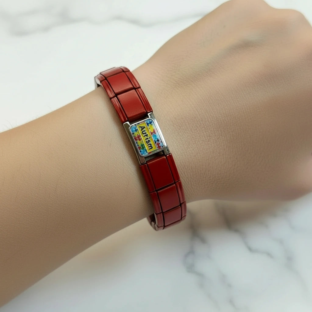 Cuore Rosso autism awareness Italian bracelet shown on wrist, featuring red enamel links and silver charm
