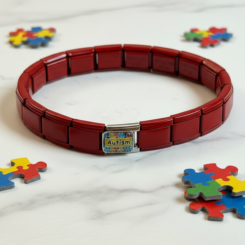 Red Italian stainless steel autism awareness bracelet displayed with colorful puzzle pieces on white background