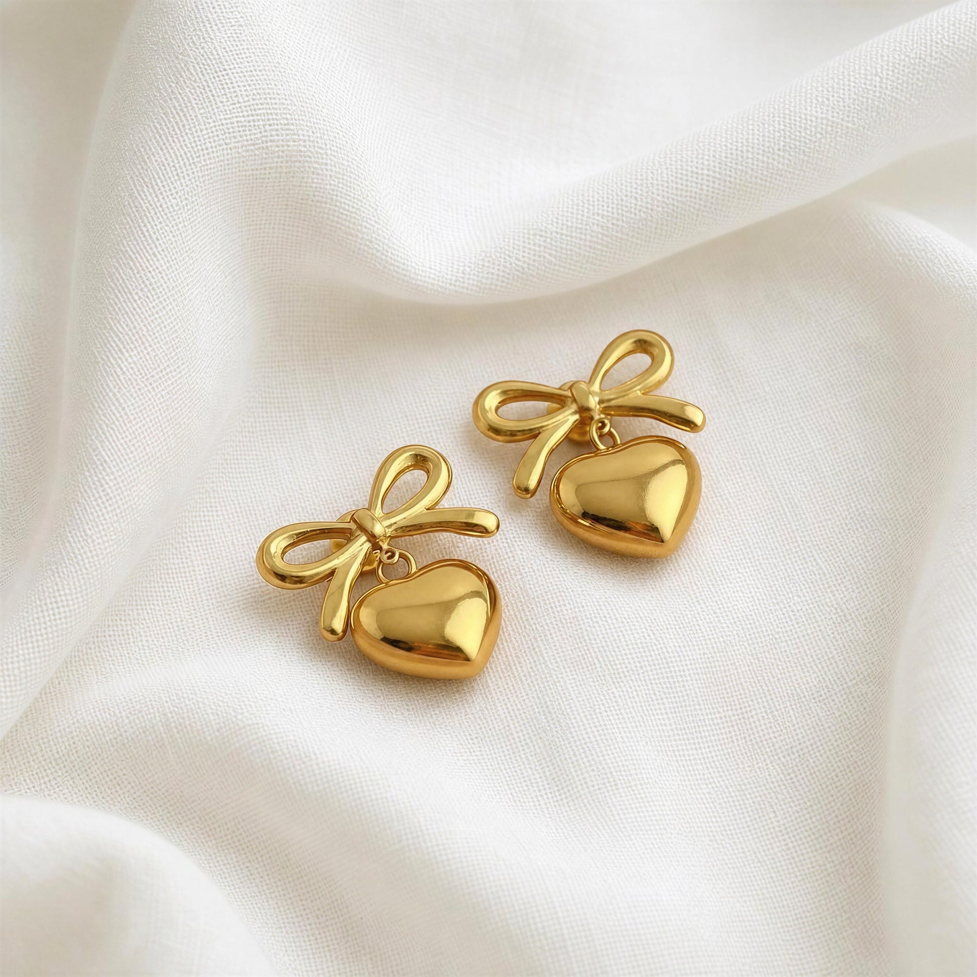 The Cupid's Knot Earrings - Gold against linen fabric 