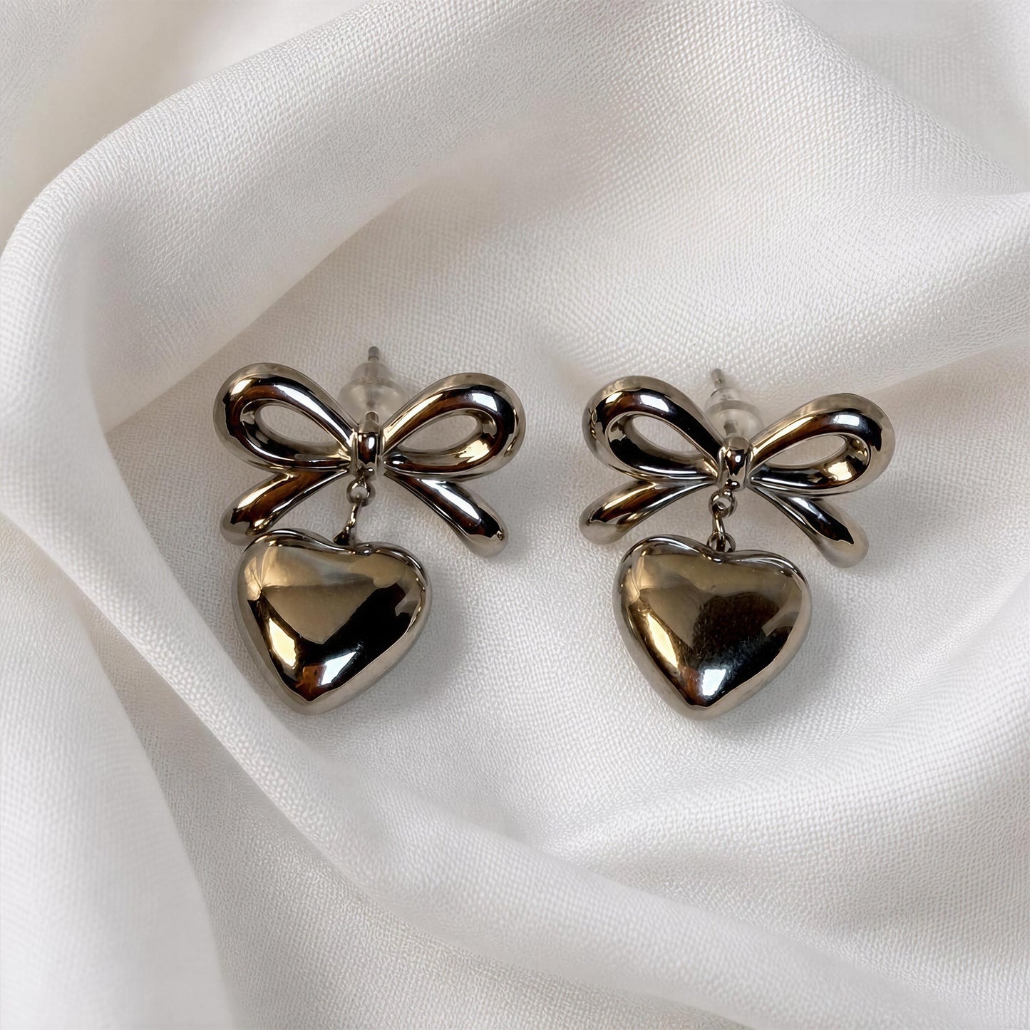 The Cupid's Knot Earrings - Silver against white fabric 