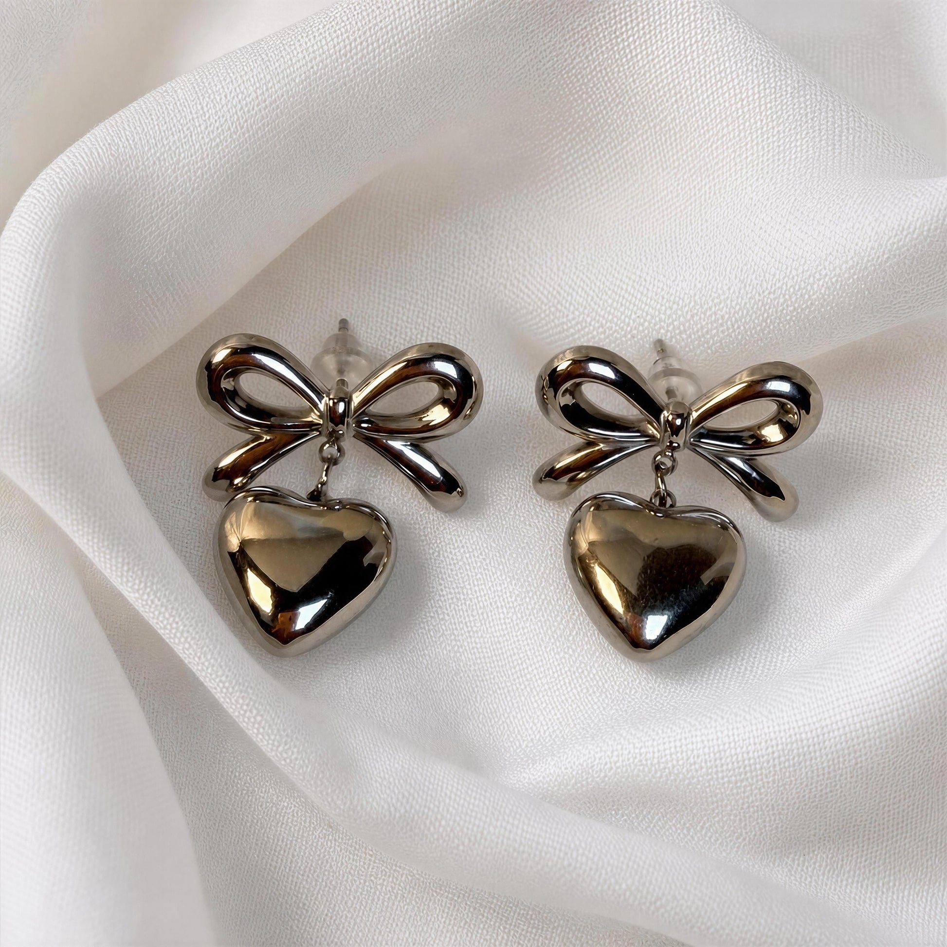 The Cupid's Knot Earrings - Silver against white fabric 