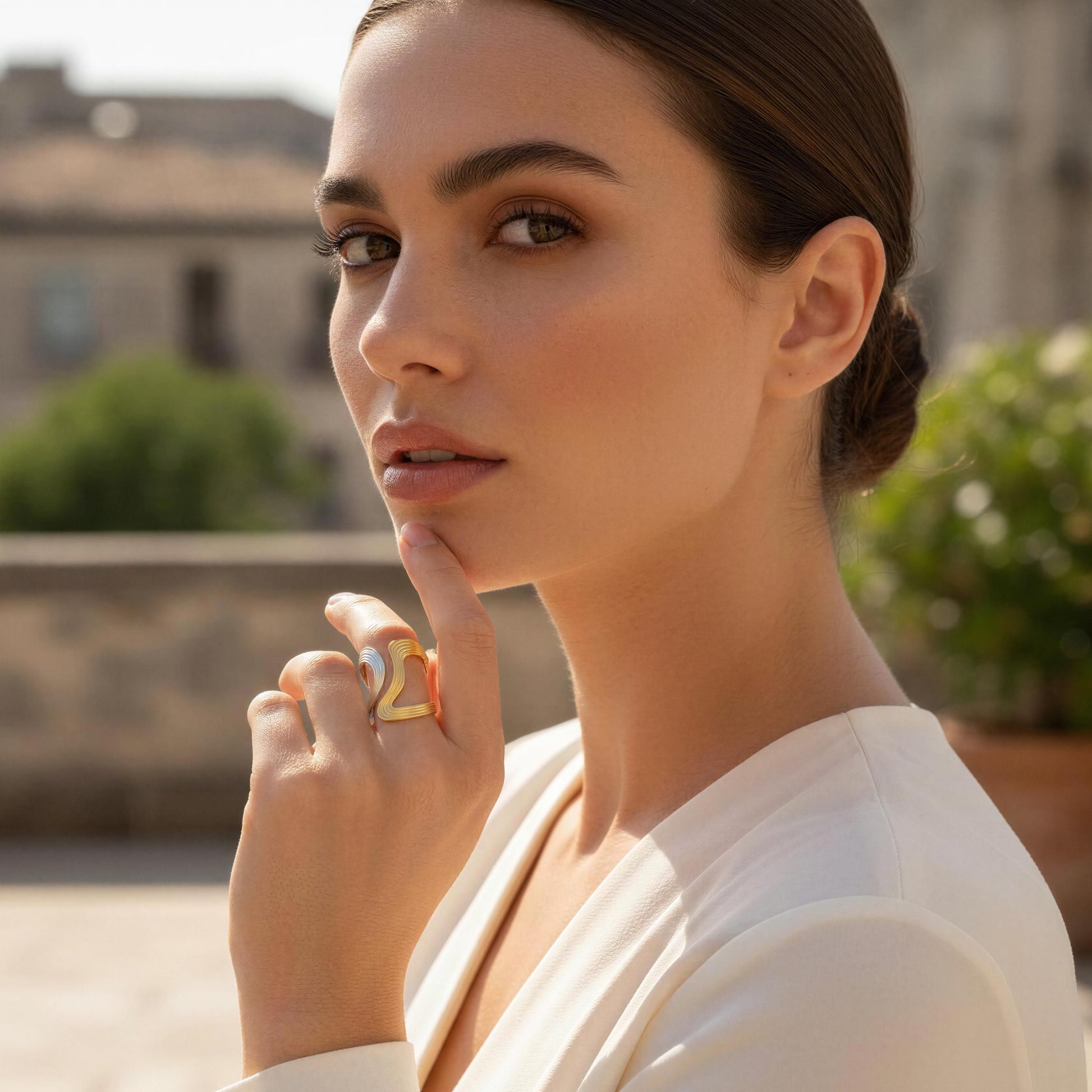 Woman wearing a large ring outdoors with blurred background